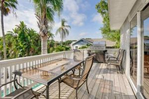 a patio with tables and chairs on a deck at Florida Life on the Water. Heated Pool, fishing, kayaks, gameroom in Palm Harbor