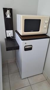 a microwave oven sitting on top of a refrigerator at Chrisserus Guest Rooms in Bloemfontein