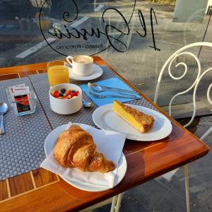 a table with two plates of bread and a bowl of fruit at Hotel Argentina in Santa Margherita Ligure