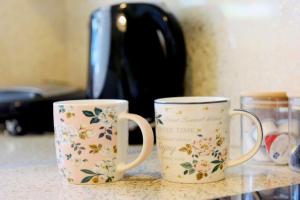 two coffee mugs sitting on top of a counter at Elli Garden View - Spacious Fully Equipped Apartment in Kremasti