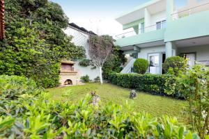 een tuin voor een huis met een open haard bij Elli Garden View - Spacious Fully Equipped Apartment in Kremasti