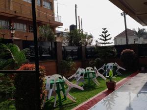 una fila di sedie bianche sedute sull'erba di SEED HOTEL a Entebbe