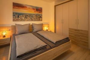 a bedroom with a large bed with two lamps at SweetHome - Poing Apartments in Poing