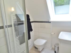 Un baño blanco con inodoro y ventana. en Wacken Ferienhaus, en Wacken 32 fotos más