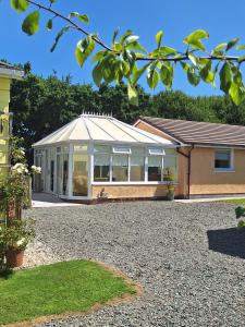 a conservatory with a white roof on a house at Thornbury Holiday Park in Thornbury
