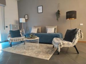 a living room with a blue couch and chairs at B&B Royal Prato in Prato