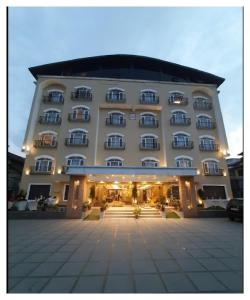 a large hotel building with a courtyard in front of it at Spring Vine Shrinagar in Srinagar