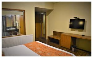 a hotel room with a bed and a television at Spring Vine Shrinagar in Srinagar
