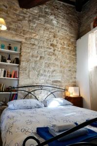 a bedroom with a bed with a brick wall at La tana del priore in Perugia