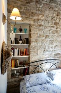 a bedroom with a brick wall with a bed and a lamp at La tana del priore in Perugia