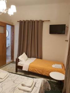 a hotel room with two beds and a television at Ermis Hotel 