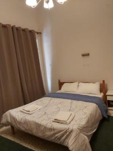a bedroom with a bed with two towels on it at Ermis Hotel 