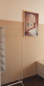 una habitación con una pintura y un estante de toallas en La Casa di Carta en Reggio Calabria