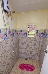 a bathroom with a shower with a red rug at Acacia Gardens in Lautoka