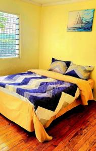 a bed with a quilt on it in a bedroom at Acacia Gardens in Lautoka