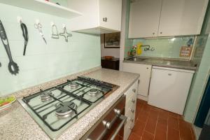 una cucina con piano cottura forno superiore accanto a un bancone di Condominio Dunelba a Marina di Campo