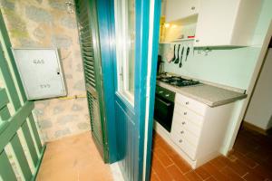 una piccola cucina con piano cottura e frigorifero di Condominio Dunelba a Marina di Campo
