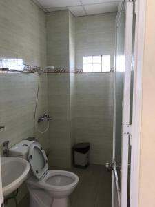 y baño con aseo, lavabo y ducha. en Phuong Hong Guesthouse en Dalat