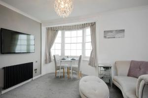 a living room with a couch and a table at Seaview Regency Apartment With Private Parking in Brighton & Hove