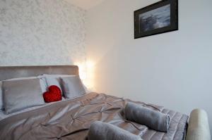 uma cama com uma almofada de coração vermelho em Seaview Regency Apartment With Private Parking em Brighton & Hove