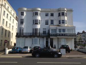 een zwarte auto geparkeerd voor een wit gebouw bij Seaview Regency Apartment With Private Parking in Brighton & Hove