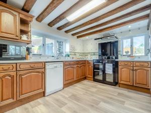 a large kitchen with wooden cabinets and white appliances at The Farmhouse - Uk45894 in Banham