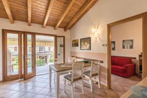 - une salle à manger avec une table, des chaises et un canapé rouge dans l'établissement Apt Gardasee Lazise Cola, à Colà