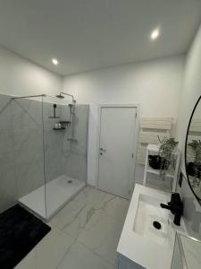 biała łazienka z prysznicem i umywalką w obiekcie Studio à Ixelles - Viaduc w Brukseli