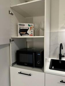 kuchnia z czarną kuchenką mikrofalową i półką w obiekcie Studio à Ixelles - Viaduc w Brukseli