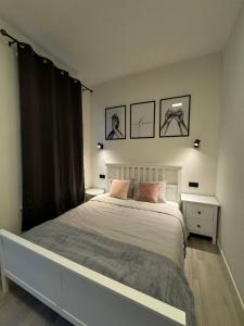 sypialnia z dużym łóżkiem i 2 zdjęciami na ścianie w obiekcie Studio à Ixelles - Viaduc w Brukseli