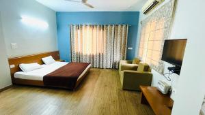a bedroom with a bed and a couch and a television at Red orchid farm in Gurgaon