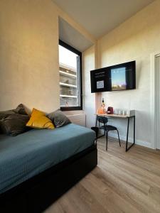 a bedroom with a bed and a desk and a television at Cunabu Apartments in Rome