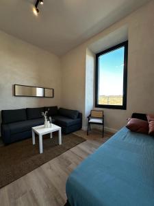 a bedroom with a bed and a couch and a table at Cunabu Apartments in Rome