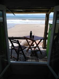 a picnic table with a drink on the beach at Balcon Del Tigre in Aguas Dulces