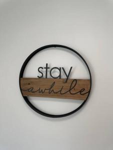 a mirror with a sign that says stay awhile at Just like home! in Huntsville