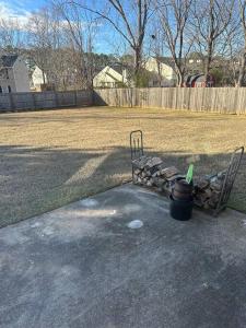 a bench and a pile of logs in a yard at Just like home! in Huntsville