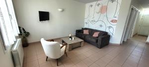 uma sala de estar com um sofá e uma mesa em T3 “Groix“- 50 m de la plage de Fort Bloqué/Ploemeur em Ploemeur