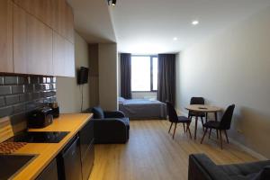 cocina y sala de estar con sofá y mesa en Roshka Apartment 108, en Gudauri