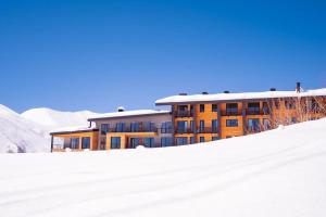 un edificio en la nieve delante en Roshka Apartment 108, en Gudauri