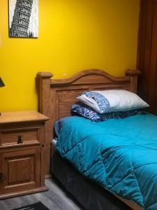 a bedroom with a bed with a wooden headboard and a table at Se arrienda casa Reñaca Bajo in Viña del Mar