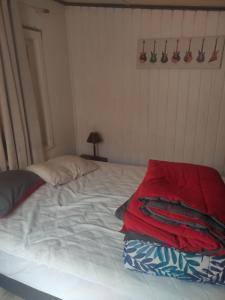 a white bed with a red blanket on top of it at Se arrienda casa Reñaca Bajo 3 habitaciones ,estacionamiento in Viña del Mar +1 photo