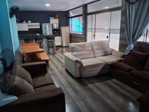 ein Wohnzimmer mit einem Sofa und einem Tisch in der Unterkunft Iguaçu House in Foz do Iguaçu