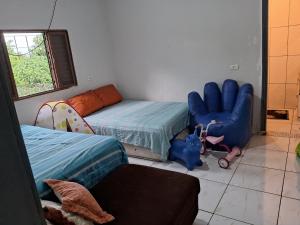 Zimmer mit 2 Betten, einem Sofa und einem Stuhl in der Unterkunft Iguaçu House in Foz do Iguaçu