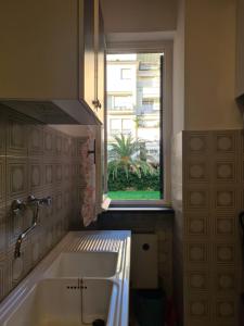 une cuisine avec un évier et une fenêtre dans l'établissement Altamarea, à Gênes