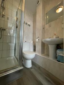 a bathroom with a toilet and a sink and a shower at Burton Villa Guest House in York