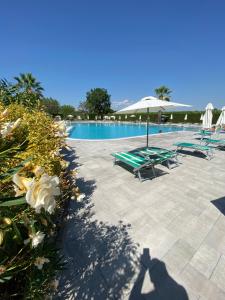 a swimming pool with lounge chairs and an umbrella at Apt Gardasee Lazise Cola in Colà di Lazise