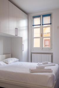 a white bedroom with a bed and a window at Casa Moro in Crema