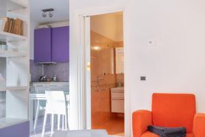 a kitchen with purple cabinets and an orange chair at Casa Moro, monolocale moderno nel centro storico in Crema