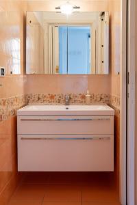 bagno con lavandino bianco e specchio di Casa Moro a Crema