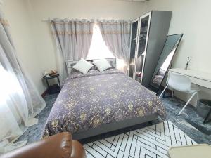 a bedroom with a bed and a desk and a window at 3 BR Cozy Home Skytrain View BKK in Ban Bang Chan